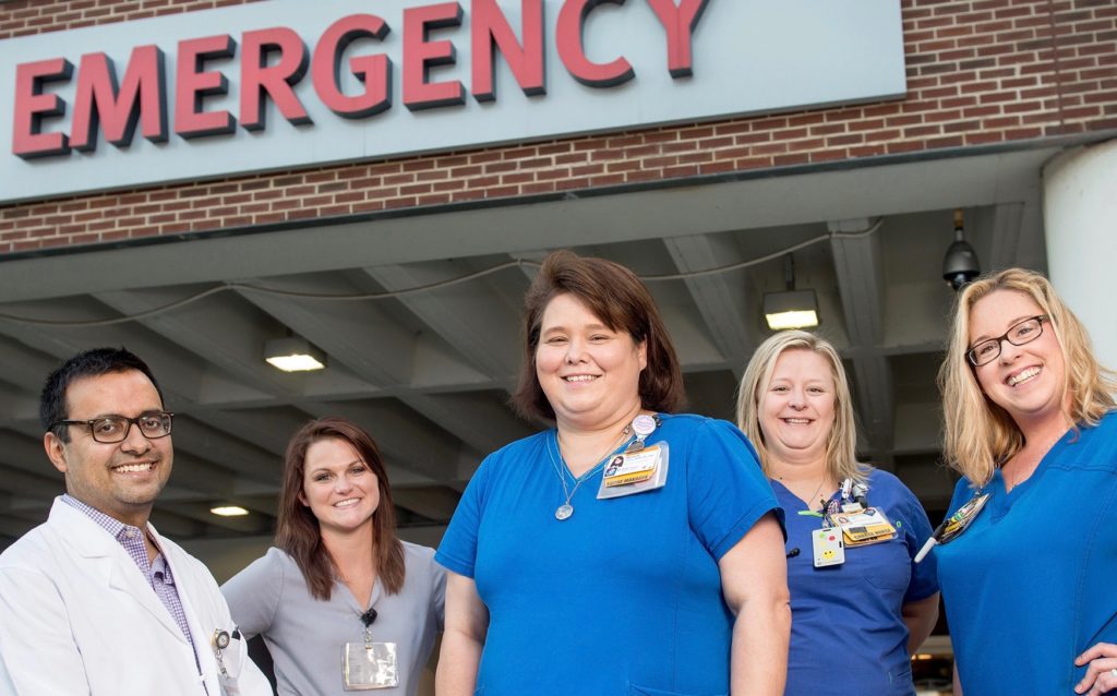 From left, Dr. Iltifat Husain, Brooke Moxley, CNA II, Michelle Collins, Nurse Manager, Melisha Bledsoe, RN, and Heather Simmons, RN, pose for a portrait outside the Emergency Department at Wake Forest Baptist Medical Center.